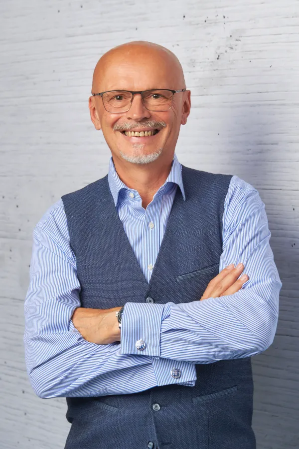 Andreas Schönemann lächelnd mit verschränkten Armen, Kontaktfoto